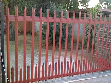 Red palisade single gate for a house.